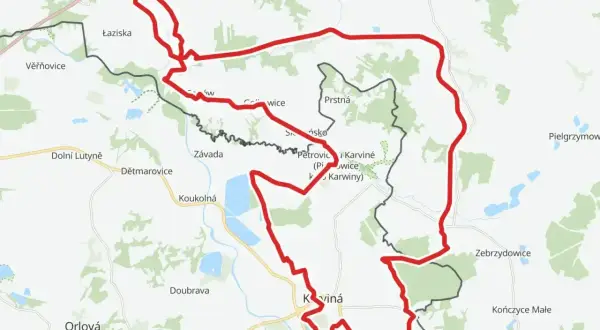 Mapa z zaznaczonym czerwonym szlakiem rowerowym, który biegnie przez tereny z nazwami miejscowości jak Łaziska, Petrovice i Karviná. To idealny żelazny szlak rowerowy do odkrywania okolicy.