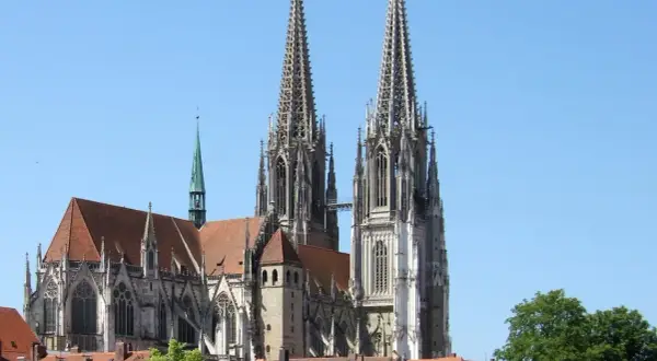 Der Regensburger Dom mit seinen markanten Türmen ragt majestätisch in den blauen Himmel.