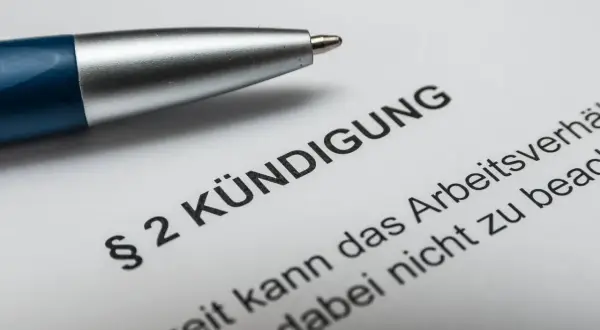 Stift liegt auf Dokument mit "Kündigung". Nach 10 Jahren im Job ist die Abfindung ein wichtiges Thema.