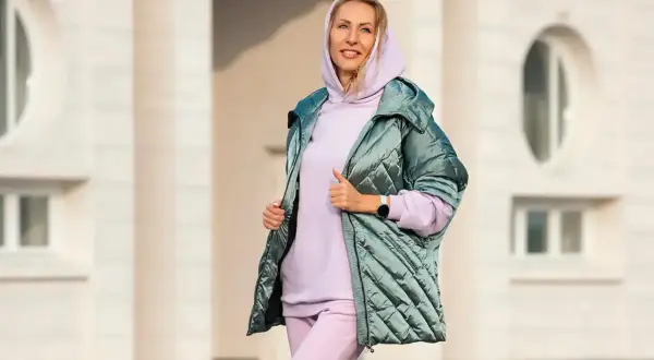 Kobieta w pastelowym dresie i pikowanej kurtce. Idealny zestaw, jak się ubrać na 15 stopni, by czuć się komfortowo i stylowo.