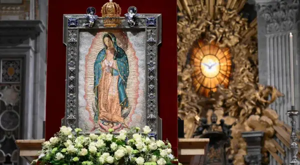 Matka Boża z Guadalupe, jej przesłanie pokoju i nadziei, w otoczeniu kwiatów i ozdobnej ramie, w kościele.