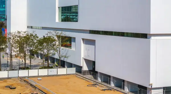Nowoczesny budynek muzeum sztuki współczesnej w Warszawie, z białymi, geometrycznymi fasadami i dużymi oknami.