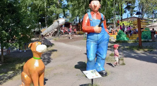 En stor staty av en mekaniker och en hund välkomnar besökare till lekparker i Stockholm.