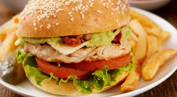 Pyszny fit burger z kurczakiem, awokado i chrupiącymi frytkami. Idealny na zdrowy posiłek.