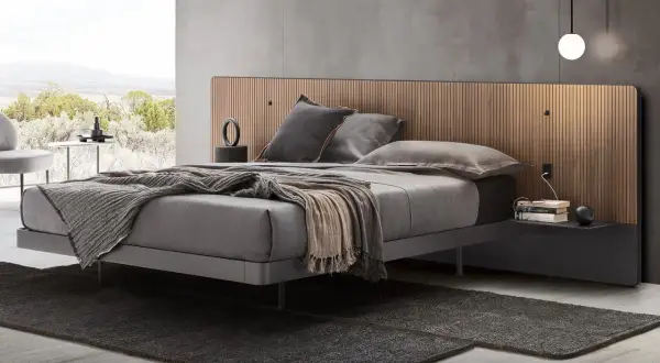 Elegante camera da letto con letto grigio e testiera in legno. Il colore grigio abbinamento crea un'atmosfera rilassante.