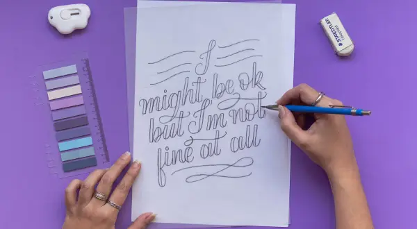 A hand draws "I might be ok but I'm not fine at all" in elegant cursive script.