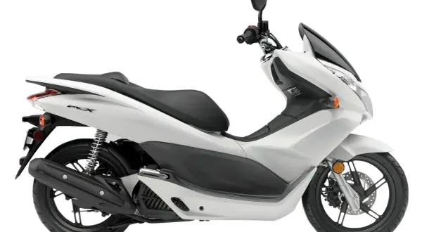 Biały skuter Honda PCX 125, znany z niskiego spalania, na białym tle.