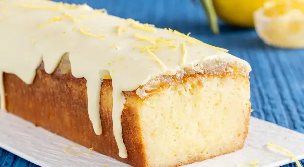 Plumcake al limone con glassa bianca e scorzette gialle, un dolce profumato e invitante.