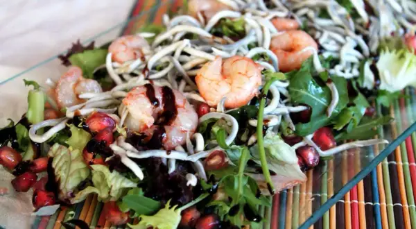 Deliciosa ensalada de gulas con gambas, granada y aderezo balsámico.