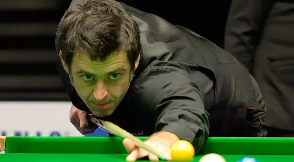 Ronnie O'Sullivan w akcji, skupiony na grze w snookera. Jego sportowa pasja widoczna w każdym ruchu.