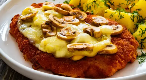 Schab po szwajcarsku z pieczarkami i serem, podany z ziemniakami i koperkiem. Pyszne danie obiadowe.