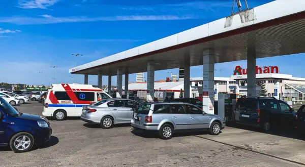 Stacja paliw Auchan. Samochody, w tym ambulans, tankują przy dystrybutorach. Sprawdzanie auchan ceny paliw.