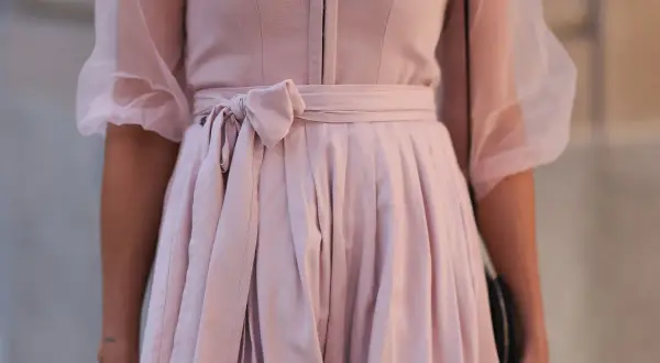 Ein zartrosa Dirndl ohne Schürze mit Puffärmeln aus Tüll. Die Taille ist mit einer Schleife gebunden.