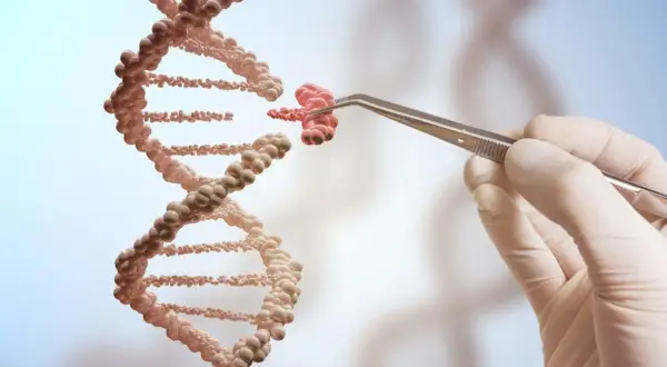 Ręka w rękawiczce trzyma pęsetą fragment DNA, jakby tworząc jego klon.