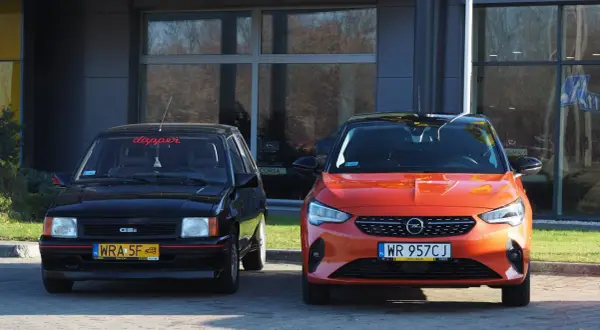 Dwa Ople: klasyczny czarny i nowoczesny pomarańczowy Opel Corsa 2022.