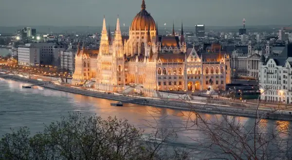 Wspaniały Parlament w Budapeszcie, oświetlony nocą, to obowiązkowy punkt, co zobaczyć w Budapeszcie. Rzeka Dunaj i miejska panorama tworzą magiczny widok.