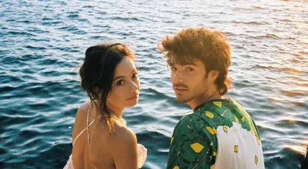 Anna Castillo y Álvaro Mel disfrutan de un atardecer junto al mar, con barcos al fondo.