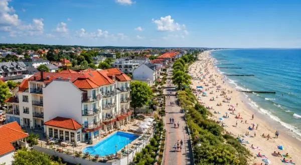 Fajny hotel nad morzem z basenem i widokiem na plażę pełną turystów. Idealne miejsce na wakacje.