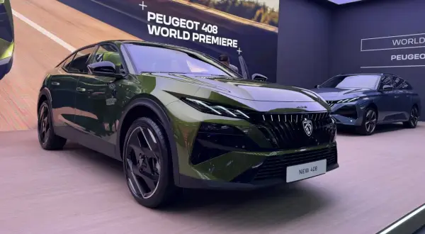 Nowy Peugeot 408 w kolorze zielonym prezentuje się na premierze światowej. Obok stoi jego granatowy brat.