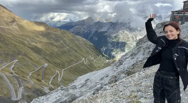 Uśmiechnięta motocyklistka na tle serpentyn w Alpach. Niesamowita przygoda na alpy motocyklem!