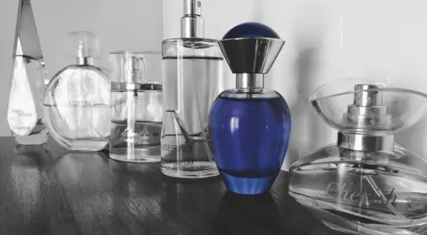 Rząd flakonów perfum, w tym Chanel i niebieski flakon, budzi pytanie: czy perfumy są szkodliwe?