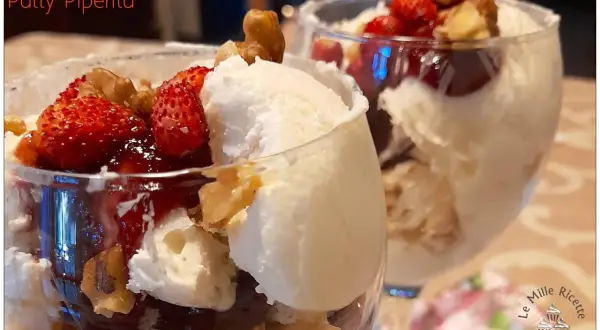 Coppa con gelato allo yogurt greco, fragole fresche, salsa rossa e noci croccanti. Un dessert fresco e goloso.