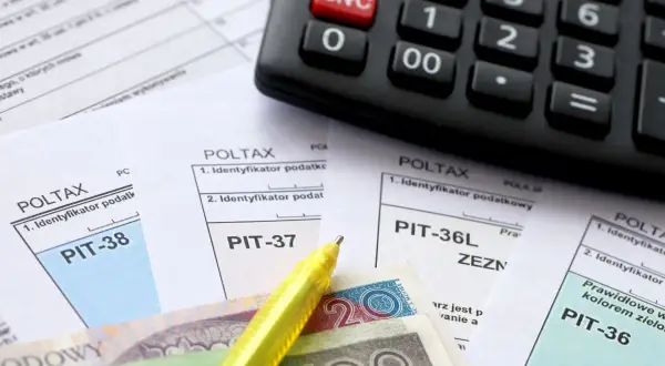 Rozliczenie PIT z ulgą termomodernizacyjną: PIT-37, PIT-38, PIT-36L, PIT-36, kalkulator, pieniądze i żółty długopis.