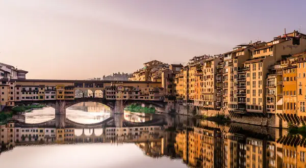 Mostra Ponte Vecchio we Florencji, idealne miejsce do zobaczenia. Złote światło odbija się w rzece Arno.