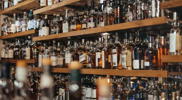Półki pełne butelek whisky. Zastanawiasz się, ile kalorii ma whisky?