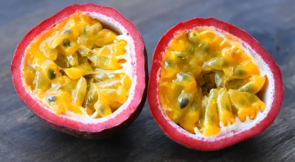Fruit de la passion coupé en deux, révélant sa pulpe juteuse et ses graines. Un délice tropical, ce fruit est réputé pour être le fruit avec le plus de fibre.