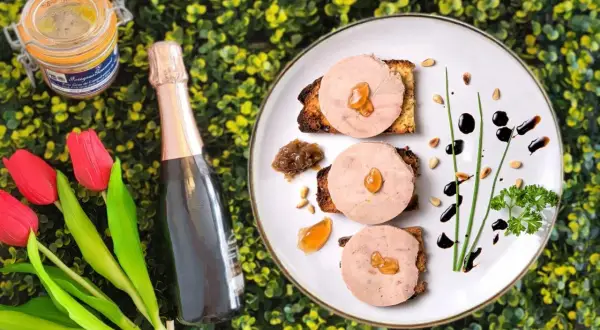 Delicioso foie gras en tostadas, acompañado de una botella de champán y tulipanes. Un festín que evoca de donde viene el foie.