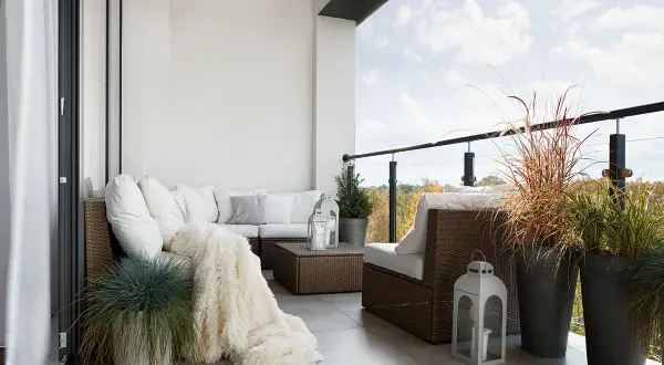 Przytulna loggia z meblami wypoczynkowymi i roślinami. Zastanawiasz się, czy loggia wlicza się do powierzchni użytkowej?