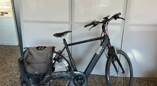 Zwarte Sparta Ion E Speed 2016 e-bike met dubbele fietstassen, klaar voor een rit.