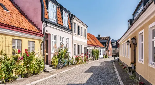 Kolorowa uliczka w Ystad, pełna kwiatów i zabytkowych kamieniczek, to idealne miejsce na spacer. Odkryj urokliwe ystad atrakcje.