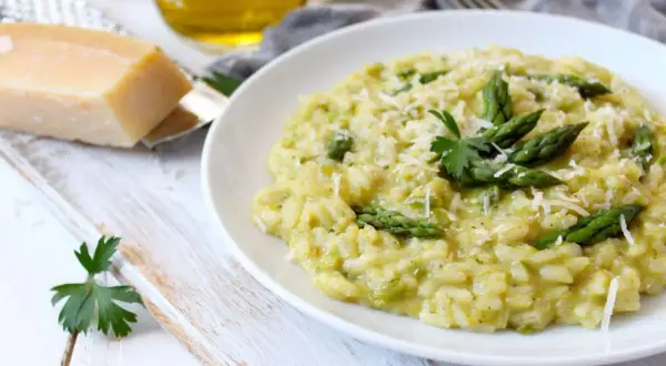 Un crémeux risotto asperges, parsemé de parmesan râpé et garni de jeunes pousses vertes. Un délice printanier.