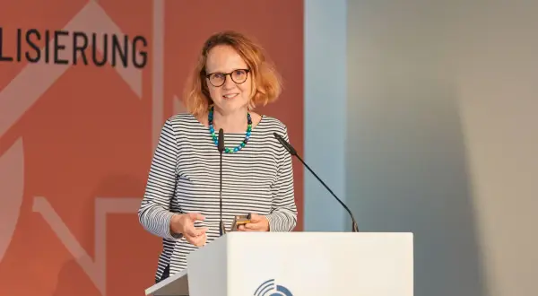 Anne Sliwka spricht bei einem Forum zur Digitalisierung. Sie trägt ein gestreiftes Oberteil und eine bunte Kette.