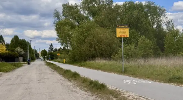 Droga rowerowa z tablicą ostrzegawczą "Kierowco! Za jazdę samochodem po drodze dla rowerów grozi mandat w wysokości do 5000 zł". Czy to rejestracja EPA, jakie miasto?