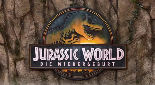 Das Logo von Jurassic World: Die Wiedergeburt, mit einem T-Rex-Kopf, bereit für den Jurassic World Stream.