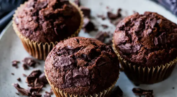 Drei saftige Schoko-Muffins mit Schokostückchen, perfekt für ein schnelles Muffins Rezept.