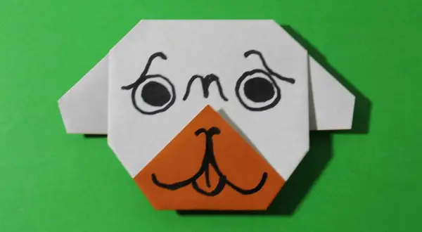 Uroczy origami piesek z pomarańczowym noskiem i czarnymi oczkami. Prosty origami piesek krok po kroku.