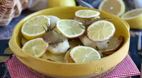 Dos de cabillaud au four, garni de rondelles de citron, de romarin et de feuilles de laurier. Un plat savoureux et parfumé.