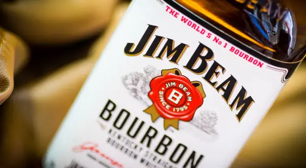 Butelka Jim Beam White Label, z charakterystycznym logo i napisem "Bourbon". Idealna na wieczór z przyjaciółmi.