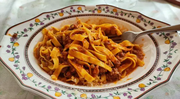 Tagliatelle al ragù, un classico per scoprire dove mangiare a Bologna. Un piatto che profuma di tradizione e sapori autentici.