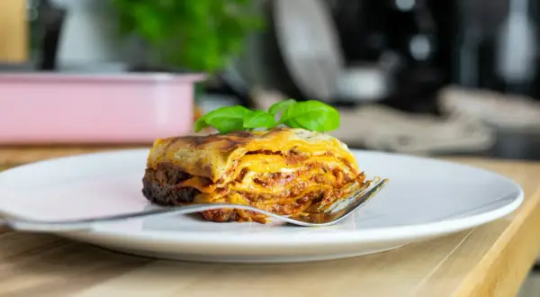 Pyszna lasagne na talerzu, idealna na jeden z 10 pomysłów na obiad. Złocisty ser i aromatyczny sos zachęcają do spróbowania.