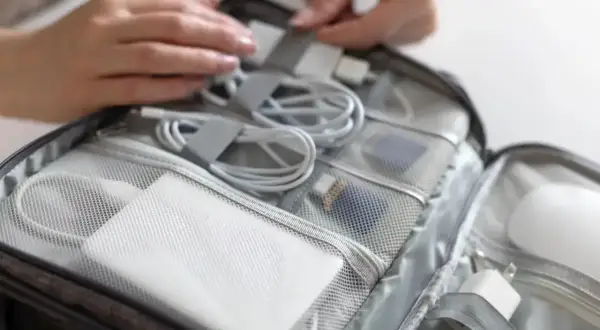 Pakowanie akcesoriów elektronicznych, w tym powerbanku, do torby podróżnej przed lotem Ryanair.