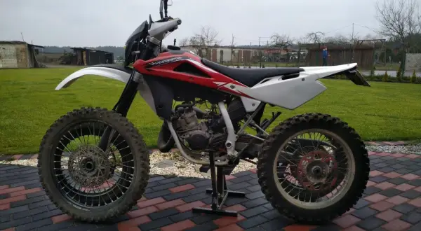 Husqvarna WRE 125, gotowa do akcji. Ten zwinny motocykl terenowy, z mocą 125cc, czeka na przygodę.