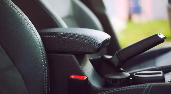 Skórzany podłokietnik i dźwignia hamulca ręcznego w samochodzie. Funkcja auto hold zapewnia komfort podczas postoju.