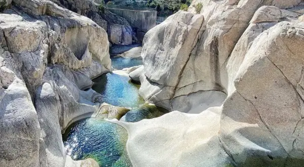 Pozzo di roccia con acqua cristallina, un luogo ideale per rinfrescarsi tra le cascate in Sardegna dove fare il bagno.