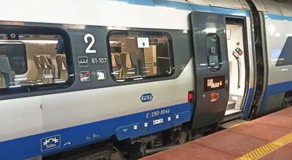 Pociąg Pendolino z otwartymi drzwiami, widoczne siedzenia i numer wagonu 2. Idealny czas na zniżki na pendolino!