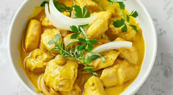 Kyckling i krämig currysås, perfekt för ett snabbt currysås recept. Garnerad med lök och persilja.